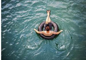 a man laying on a raft in the water at Senderos del Mar, Hotel con AC, Piscina, cerca de Tayrona in Buritaca