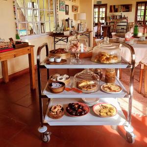 a food cart with different types of pastries on it at La Perdida Casa de Campo in San Antonio de Areco +55 photos