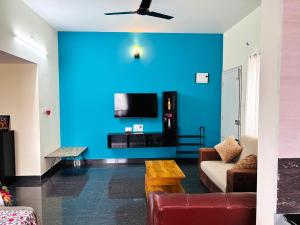 a living room with a blue wall at The Prime Residences of Samuels Comfort Homes in Bangalore