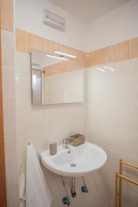 a bathroom with a white sink and a mirror at Ravè in Praia a Mare