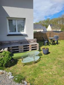 a backyard with a bench and a table and chairs at chambre d'hôte in Pleslin-Trigavou +3 photos