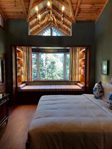 a bedroom with a large window and a large bed at Abbotsford Prasada Bhawan in Nainital