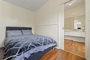 a bedroom with a bed and a bathroom at Tiny house at Gilderoy Valley Views in Yarra Junction