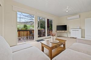 a living room with a couch and a tv at Tiny house at Gilderoy Valley Views in Yarra Junction