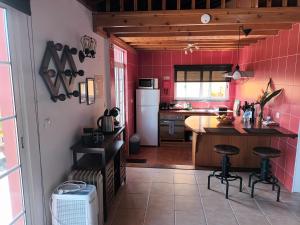 a kitchen with pink tiles on the walls at Casinhas in Praia do Almoxarife