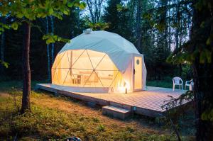 a large dome tent with a deck in a forest at Bubble House glamping tent Odulemma in Odulemma