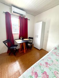 a room with a bed and a table and a window at Apartamento no Centro in Manaus