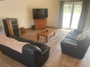 a living room with two couches and a tv at Casa Borboleta in Chão de Lamas