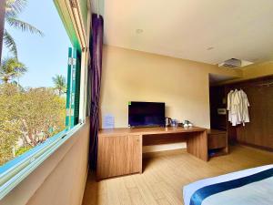 a room with a desk and a large window at My Marina Beach Hotel Phu Quoc in Phú Quốc