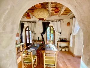 a dining room with a table and chairs and an archway at Maison d'hôtes de charme Kasbah de Mimi Gorges du Dades in Aït Yous