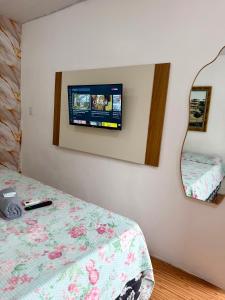 a bedroom with a bed and a tv on the wall at Apartamento no Centro in Manaus