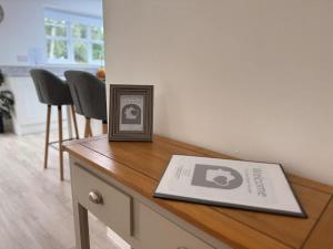 a picture frame sitting on top of a wooden table at Low Street Escape 3 Bed, Sleeps 9, Gated Drive, WiFi, Contractors in Great Wyrley +26 photos