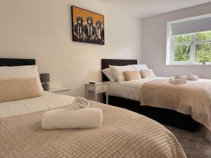 a bedroom with two beds with towels on them at Low Street Escape 3 Bed, Sleeps 9, Gated Drive, WiFi, Contractors in Great Wyrley