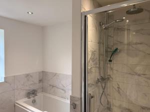 a bathroom with a shower and a bath tub at Low Street Escape 3 Bed, Sleeps 9, Gated Drive, WiFi, Contractors in Great Wyrley