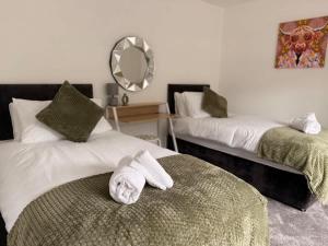 a hotel room with two beds with towels on them at Low Street Escape 3 Bed, Sleeps 9, Gated Drive, WiFi, Contractors in Great Wyrley