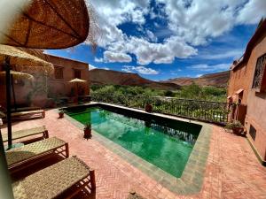 a swimming pool in the middle of a patio at Maison d'hôtes de charme Kasbah de Mimi Gorges du Dades in Aït Yous