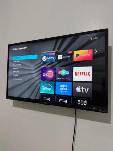 a flat screen tv hanging on a wall at Quarto no centro in Manaus