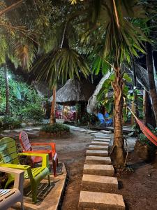 a resort with colorful chairs and a palm tree at Hospedaje VILLA CRETA in Puerto Limón