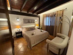 a bedroom with a bed and a chair at Serena Villa in Ibiza Town +70 photos