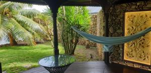 a hammock on the porch of a house at Robinson's Cove Villas in Papetoai
