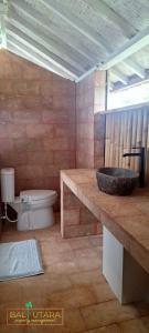 a bathroom with a sink and a toilet at Rumah Putih Beachfront Bungalow in Tegallengah +42 photos