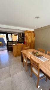 a kitchen and dining room with a wooden table and chairs at Cabañas Indómita in El Bolsón