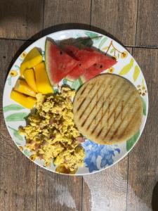 a plate of breakfast food with toast and fruit at Hospedaje VILLA CRETA in Puerto Limón
