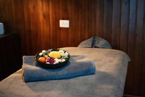 a bowl of flowers sitting on top of a bed at Yangkhil Resort in Tongsa +8 photos