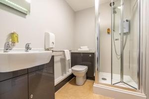 a bathroom with a shower and a toilet and a sink at Riverside Hotel in Cirencester +25 photos