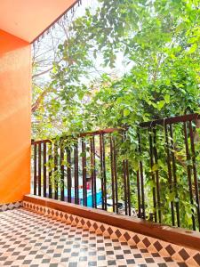 a balcony with a black railing and a tree at The Prime Residences of Samuels Comfort Homes in Bangalore