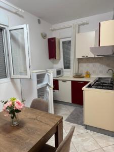 a kitchen with a wooden table and a kitchen with white cabinets at Appartament Luna in Šorići
