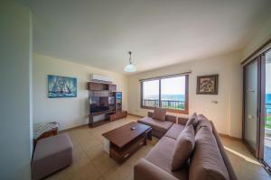 a large living room with a couch and a tv at Infinity Blue Villa w Pool in Pomos