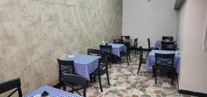 a dining room with blue and white tables and chairs at Hotel Distrito Unicentro in Medellín