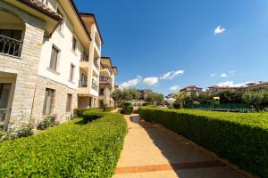 a walkway between two buildings with green hedges at Burgas Beach Resort Apartments in Burgas +95 photos