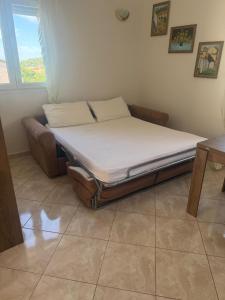 a bed sitting in a room with a window at Appartament Luna in Šorići