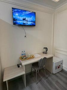 a desk in a room with a television on the wall at Ayvon Guesthouse in Samarkand