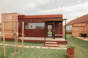 a house with a glass door in a yard at Rusty Cabin -Tiny House in Neustift an der Lafnitz