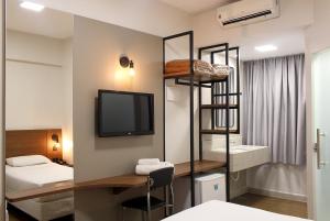 a room with a room with a bed and a tv at Premium Executive Hotel Itabira in Itabira