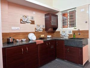 a kitchen with wooden cabinets and a counter top at The Prime Residences of Samuels Comfort Homes in Bangalore