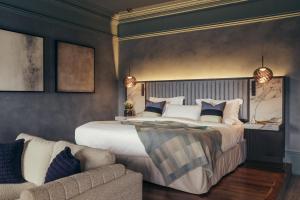 ein Schlafzimmer mit einem großen Bett und einer Couch in der Unterkunft Lyla Rooms in Edinburgh