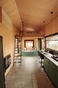 a room with a bunk bed and a kitchen at Rusty Cabin -Tiny House in Neustift an der Lafnitz