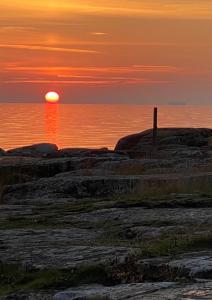a sunset over the ocean with the sun setting at Trädgårdscafé Pedalen B&B in Halmstad