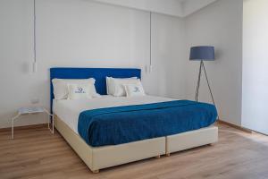 a bedroom with a large bed with a blue blanket at Domo20 Hotel & Rooftop in Vico Equense