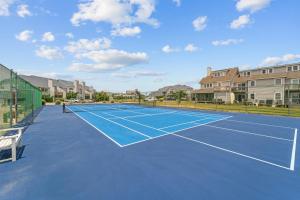 a tennis court with a player on it at Flip Flops Inn in Duck