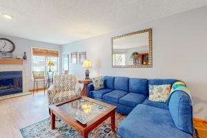 a living room with a blue couch and a table at Flip Flops Inn in Duck
