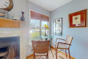 a living room with a table and chairs and a fireplace at Flip Flops Inn in Duck
