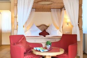 a bedroom with a bed with a table and two chairs at Altkölnischer Hof in Bacharach