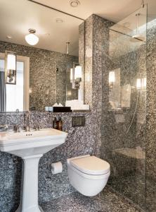 a bathroom with a toilet and a sink and a shower at Sand Hotel by Keahotels in Reykjavík +72 photos