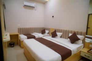 a hotel room with two beds in it at Shree Guru Ashray in Ujjain +3 photos
