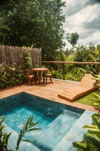 a pool with a table and chairs on a deck at Reserva Mazu in São Miguel dos Milagres